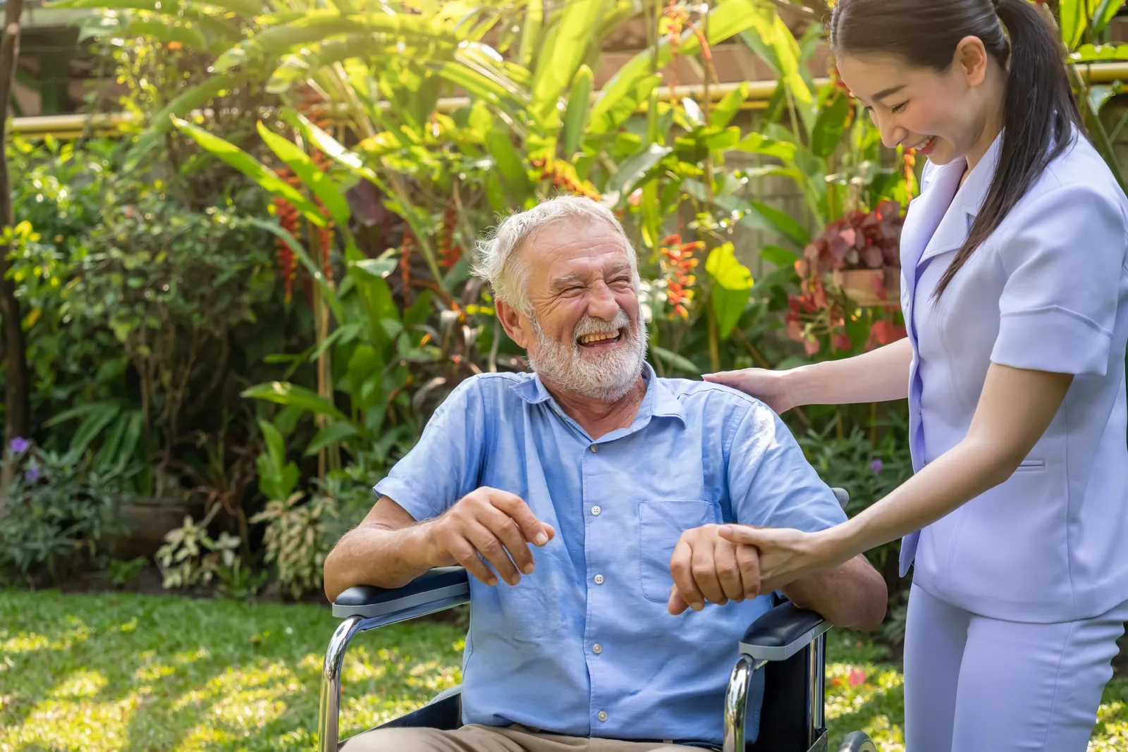 Infirmière souriante tenant la main d'un retraité